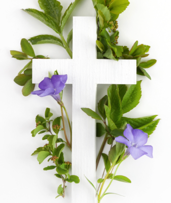white cross with green leaves and purple flowers